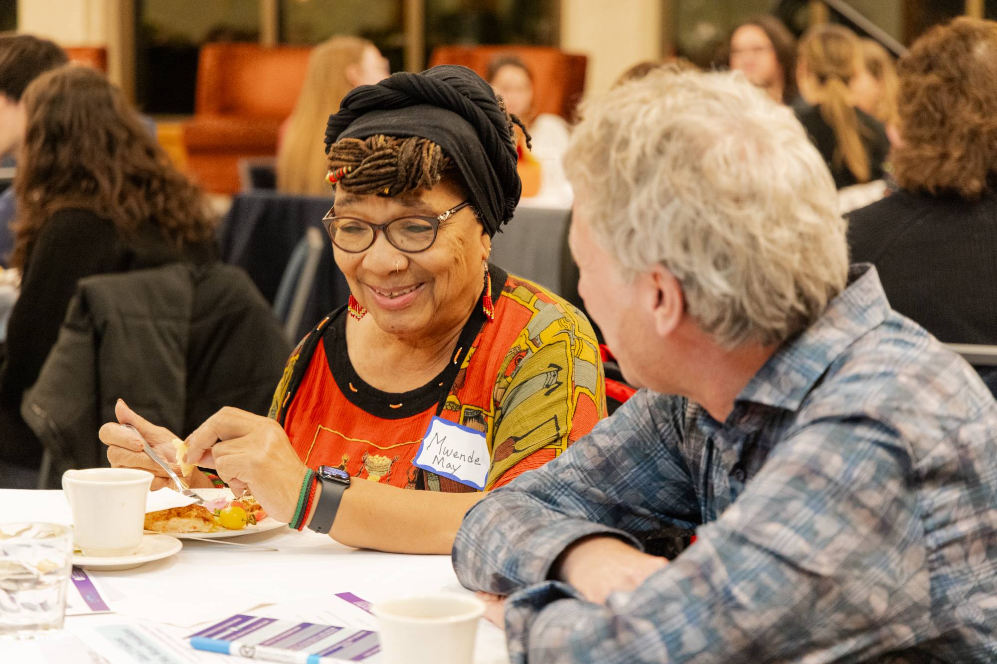 two older attendees smiling at one another